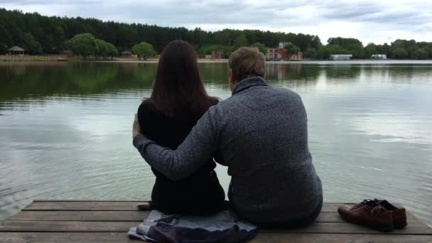 幸福的夫妇坐在湖边的平台上 — 图库视频影像