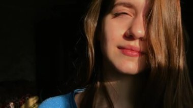 Güneş ışığında güzel saçlı gülümseyen güzel kız.