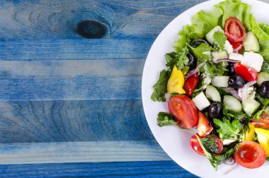 Sebze salatası salatalık kapuçino domates ve zeytin beyaz tabakta özgün mavi arkaplan kopya alanı