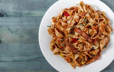 Kopi uzayının beyaz bir tabağında domates ezmeli baharatlı spagetti.