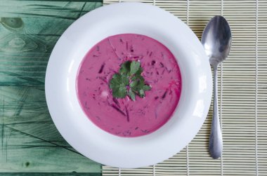 Soğuk pancar çorbası ve sebzeler beyaz bir tabakta çok renkli arka planda fotokopi alanı ile.