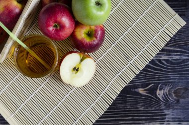 Doğal bir arka planda şeffaf bir bardakta kırmızı ve yeşil elma suyu.