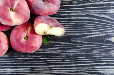 Düz şeftaliler koyu ahşap arkaplanda İncir şeftalileri üst görünümde