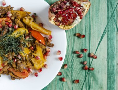 Domatesli fırında dana eti otlar ve nar meyveleriyle süslenmiş doğal arkaplan rengi.