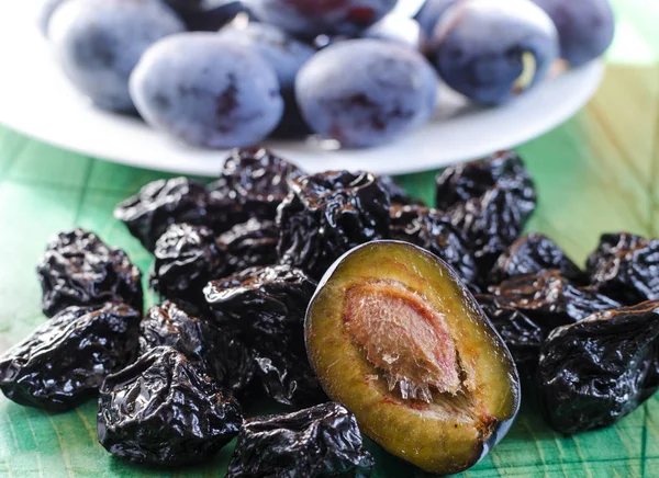 plum and dried plum on a wooden background blurred background prunes