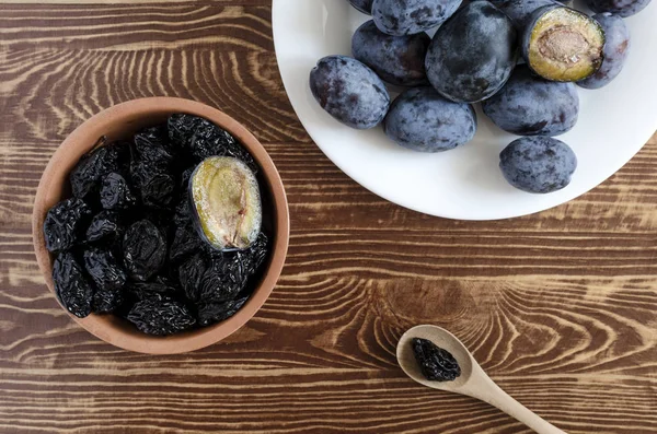 plum and dried plum on a wooden background top view prunes