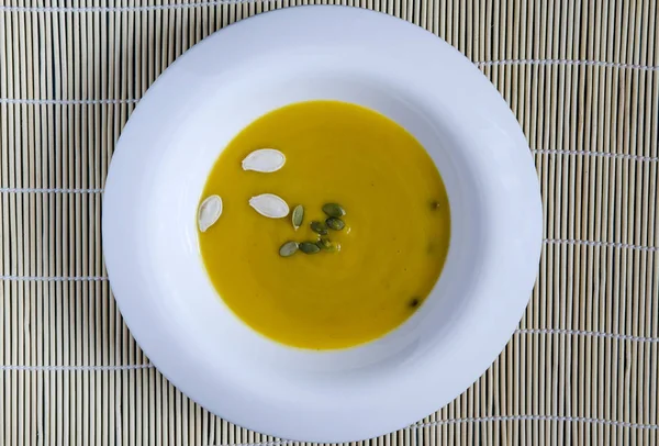 Soupe Citrouille Dans Une Assiette Blanche Graines Citrouille Fond Clair — Photo