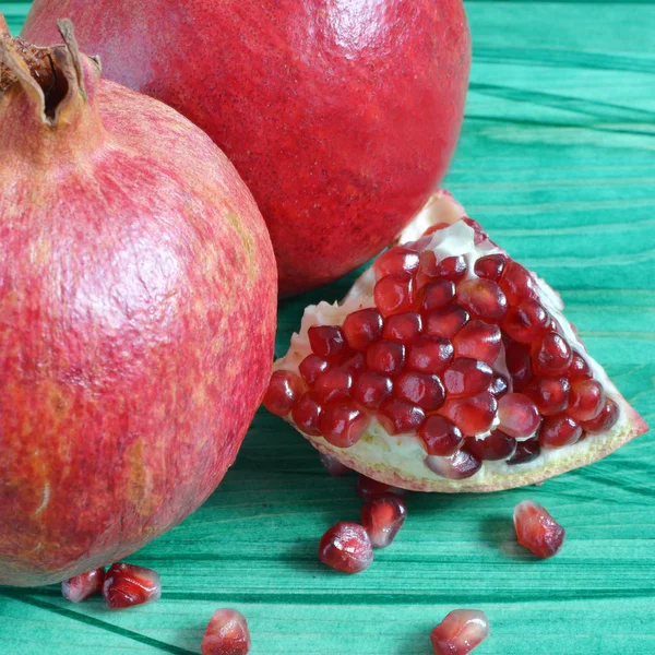 Saftige Granatapfelfrucht Mit Leuchtend Roten Beeren Auf Grünem Hintergrund — Stockfoto