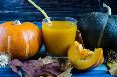 yeşil ve portakal kabağı ve kabak suyu şeffaf kase içinde ahşap arka planda