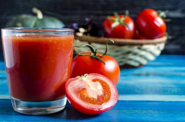 Ahşap arka planda şeffaf domates suyu. Doğal ışık.