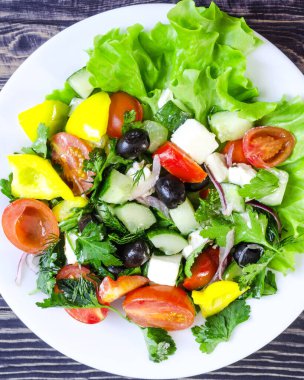 Sebze salatası salatalık biber peynirli zeytin beyaz tabakta yakın plan