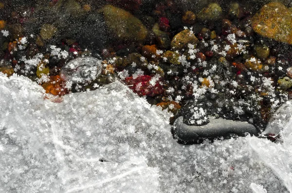 texture of small stones covered with transparent ice large snow crystals on ice