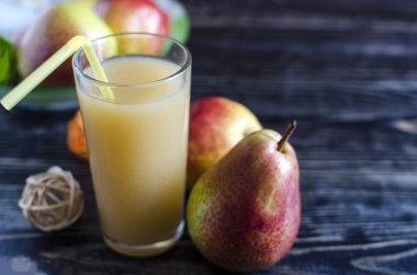 Bir bardak armut suyu ve arka planda koyu bulanık armut Kopi alanı.