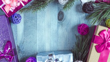 Noel süslemeleri. Renkli hediye kutuları. Ahşap arka planda yeşil köknar dalları.