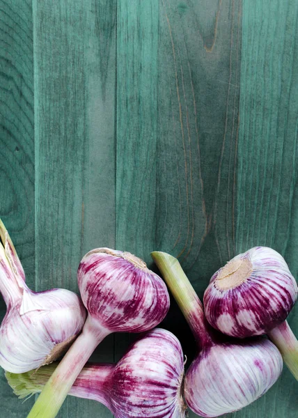 stock image large heads of fresh garlic on a blue wooden background vertical