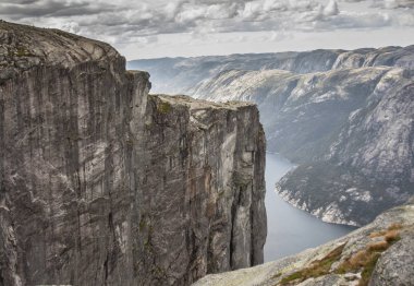  Cliff yüz gri bulutlar altında gri. Norveç Fiyordları