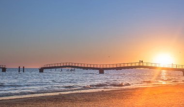 Harap olmuş bir rıhtımın arka planına karşı gün batımı: Geçen zaman ve değişim ihtiyacı fikri..