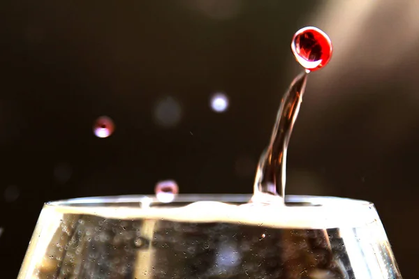 Bardağı içinde dans eden su damla.