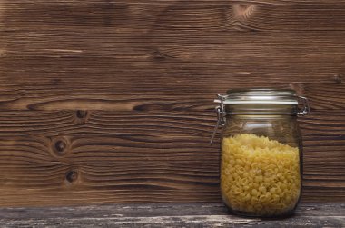 Kopya alanı ile makarna makarna kavramı arka plan. Makarna bir cam kavanoz kap içinde. 