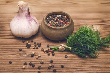 Sarımsak ampul, kahverengi ahşap masa arka plan üzerinde kase ve dereotu yeşil biber bezelye. Organik maddeler.