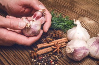 Adam cook sarımsak elinde tutar ve bu kabuğu temizler. Malzemeler hazırlanması.