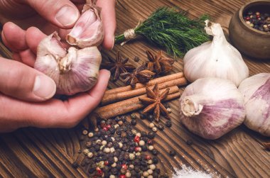 Adam cook sarımsak elinde tutar ve bu kabuğu temizler. Malzemeler hazırlanması.