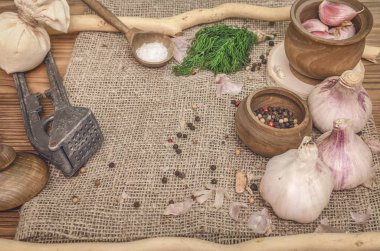 Sarımsak ampul ve karanfil, biber bezelye, tuz, kahverengi ahşap masa arka plan üzerinde yeşil dereotu. Farklı baharatlar. Marine için malzemeler.