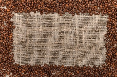 Kahve çekirdekleri ile kopya alanı çuval bezi arka plan üzerinde Center'da sınır çerçeve.