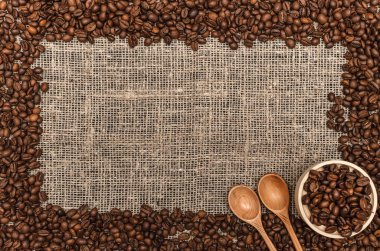 Kahve çekirdekleri ile kopya alanı çuval bezi arka plan üzerinde Center'da sınır çerçeve.