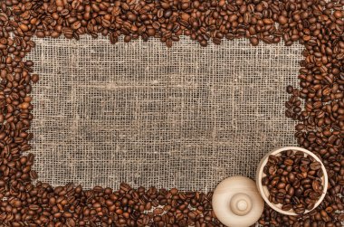 Kahve çekirdekleri ile kopya alanı çuval bezi arka plan üzerinde Center'da sınır çerçeve.