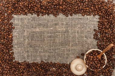 Kahve çekirdekleri ile kopya alanı çuval bezi arka plan üzerinde Center'da sınır çerçeve.