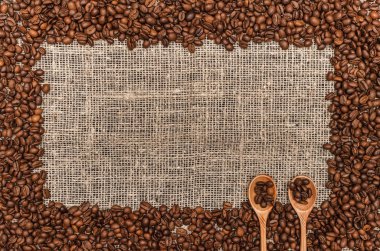 Kahve çekirdekleri ile kopya alanı çuval bezi arka plan üzerinde Center'da sınır çerçeve.