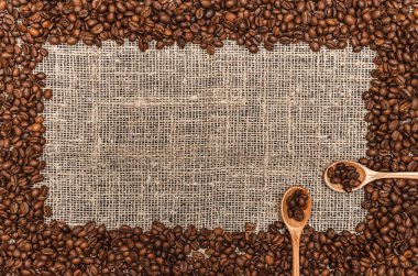 Kahve çekirdekleri ile kopya alanı çuval bezi arka plan üzerinde Center'da sınır çerçeve.