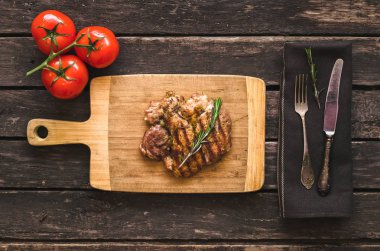 Izgara hindi eti ve ahşap arka plan üzerinde kırmızı domates.