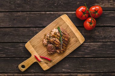Izgara hindi eti ve kırmızı domates ve ahşap zemin üzerine kırmızı biber biber.