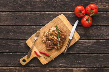 Izgara hindi eti ve kırmızı domates ve ahşap zemin üzerine kırmızı biber biber.