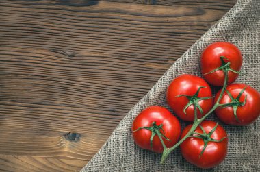 Kahverengi ahşap masa arka plan üzerinde kırmızı taze domates.