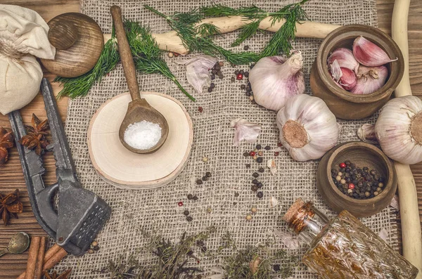 Sarımsak ampul, biber bezelye, tuz, yeşillik dereotu, Yıldız anason ve tarçın kahverengi ahşap masa arka plan üzerinde. Farklı baharatlar.