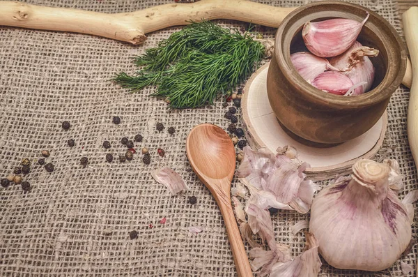 Sarımsak ampul ve karanfil, biber bezelye, tuz, kahverengi ahşap masa arka plan üzerinde yeşil dereotu. Farklı baharatlar. Marine için malzemeler.