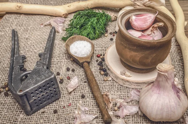 Sarımsak ampul ve karanfil, biber bezelye, tuz, kahverengi ahşap masa arka plan üzerinde yeşil dereotu. Farklı baharatlar. Marine için malzemeler.