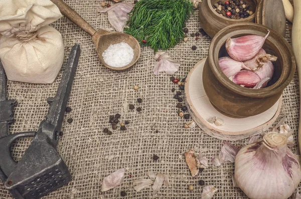 Sarımsak ampul ve karanfil, biber bezelye, tuz, kahverengi ahşap masa arka plan üzerinde yeşil dereotu. Farklı baharatlar. Marine için malzemeler.