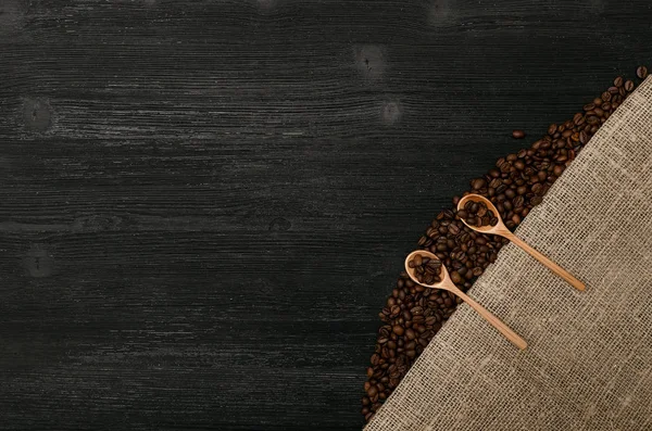 Kaffeebohnen Holzlöffeln Auf Sacktuch Leinwand Und Kaffee Auf Schwarzem Tischhintergrund — Stockfoto