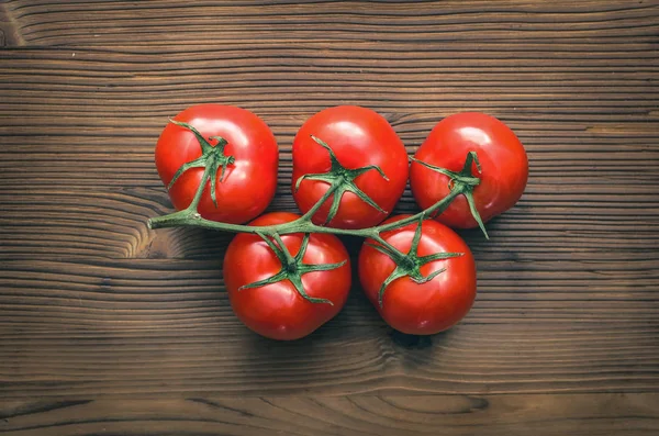 Kahverengi ahşap masa arka plan üzerinde kırmızı taze domates.