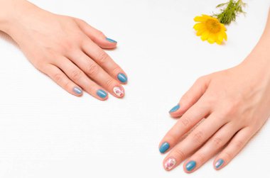 Kadın el manikür çivi ve sarı çiçek.