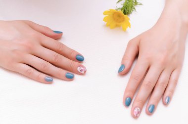 Kadın el manikür çivi ve sarı çiçek.