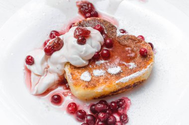 Kızılcık ve pudra şekeri ve ekşi krema Beyaz ahşap masa arka plan üzerinde plaka üzerinde taze pişmiş lor.