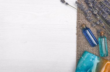 Spa aromaterapi kavramı arka plan kopya alanı, düz ile yatıyordu. Lavanta çiçeği, katı sabun ve uçucu yağ beyaz ahşap masa arka plan üzerinde.