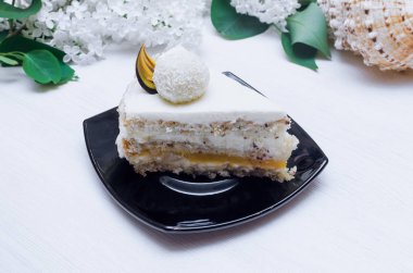 Fındıklı, doğal krem ve marmelat katman tutku meyve peynir-Hindistan cevizi kreması ve ağaç dalı üzerinde beyaz leylak çiçekler ile sünger kek.