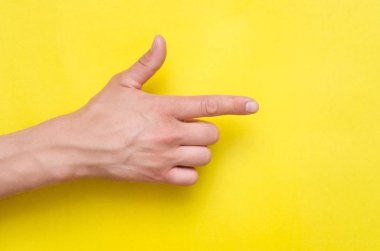 Erkek el parmağı üzerinde sarı arka plan izole tarafından işaret.