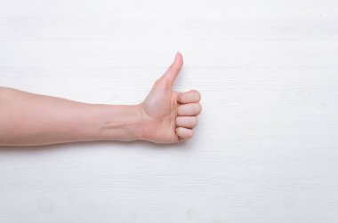 Eller kadın beyaz ahşap arka plan üzerinde izole jest Yaşasın gösterilen.